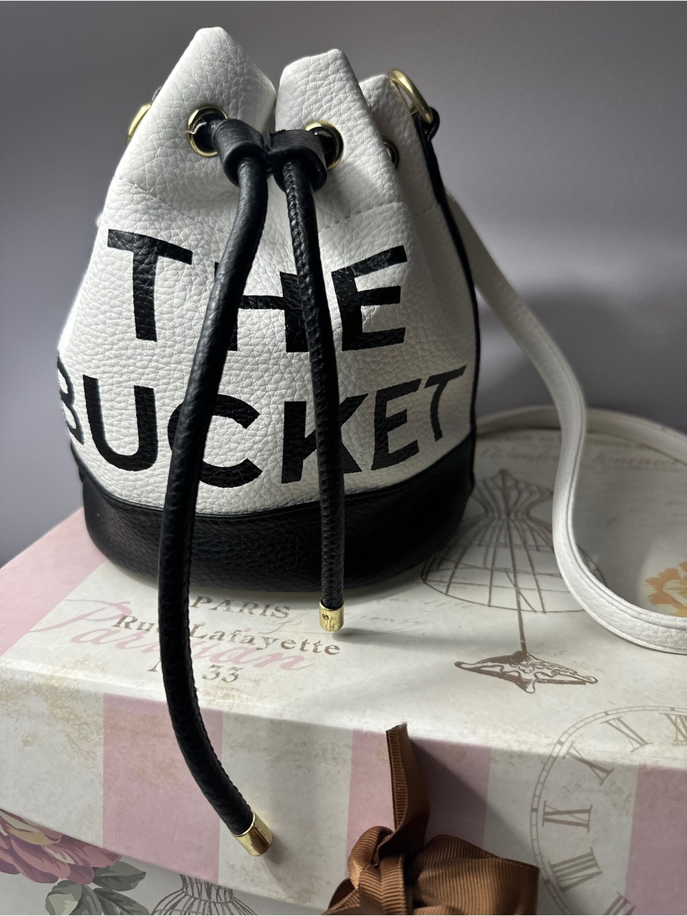 The Bucket mini Drawstring Bucket Bag with adjustable crossbody strap.